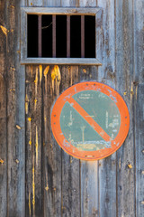 Cartel de prohibido aparcar en la puerta de madera de un garaje 
