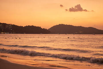 Panorama of Patong beach and Andaman sea on Phuket in Thailand during sunset. Pink and gold colors, view of the hills