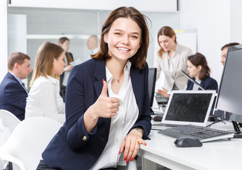 Succesful smiling young businesswoman working in office