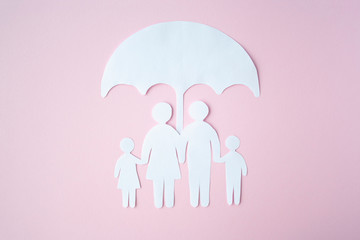 Concept of Social Protection Family. Paper cut Family Under Umbrella on bright pink background. Life insurance, family protection