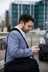 Businessman using smartphone Outdoors in front of Office Building. Texting, Sms, Internet Surfing, App, Communication. Corporate Business Concept