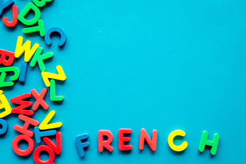 Learn French. Concept with letters on blue background top-down copy space