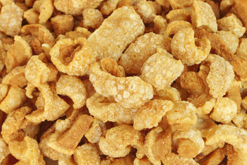 Close up of pork snack or pork scratching at market, crispy fried pork skin and blistered is traditional food in the north of Thailand.