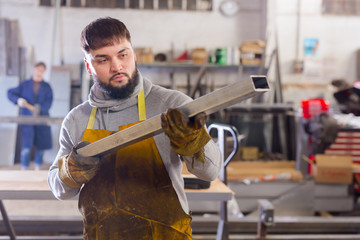 Portrait of man looking at profile steel tube