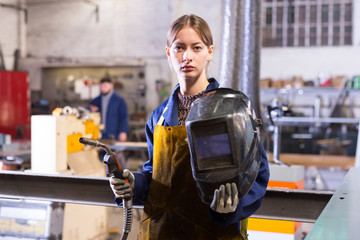 Young woman using welder for construction work
