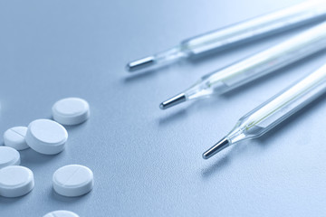 Fototapeta premium Closeup of a medical mercury thermometer and white tablets