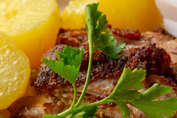 Juicy, baked pork ribs with new potatoes and herbs