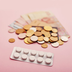 Money and pills. Pills of different colors on money, medicine concept, cash. Heap of various pills. Coronovirus, quarantine, epidemic, pandemic, flu, cold,illness. Medicine concept and health.