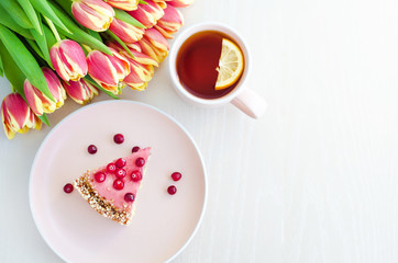 flat lay for breakfast, morning with flowers tulips, cake, tea in pink mug on white background. womens, mothers, Valentines Day, birthday. copy space, soft focus