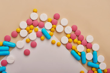 Assorted pharmaceutical medicine pills, tablets and capsules on beige background. Heap of various pills. Coronovirus, quarantine, epidemic, pandemic, flu, cold,illness. Medicine concept and health