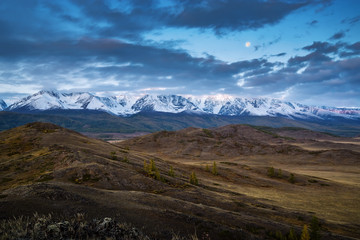Morning in the Kurai steppe, the Moon over the North Chuysky ridge. Kosh-Agachsky District, Altai Republic, Russia