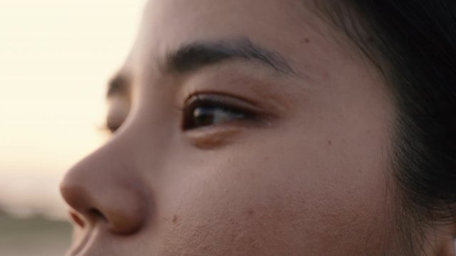 Close up eyes athlete asian woman looking at the view while standing outdoors after running jogging exercising workout at sunset fitness and healthy lifestyle concept.
