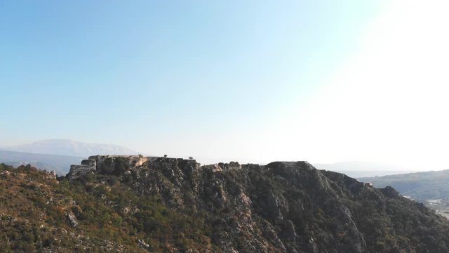 Drone circeling arount the fortress of Knin with the mountains and blue sky in the background