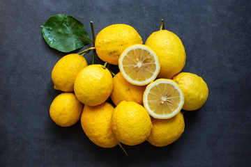 Fresh yellow lemon on dark gray background.