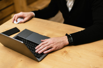 Workspace of a young office worker. A man is typing on a laptop, looking for information, surfing the Internet or working from his home. Freelance concept