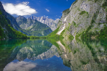 lake Obersee with reflections and view to the alps mountains with ducks