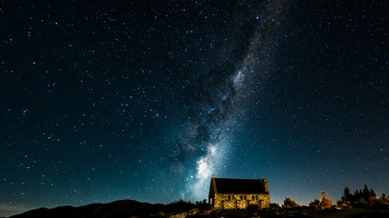 Backgrounds night sky with stars and milky way over the church at tekapo lake south island new...
