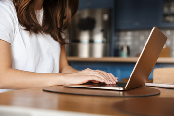Cropped image of young woman typing on laptop