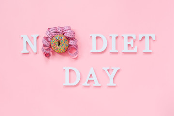 Text No diet day and abstract funny face of woman from donut with eyes and hair from centimeter tape on plate on pink background. Concept International No Diet Day, 6 may Top view Flat lay
