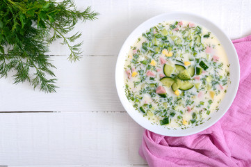Cold summer soup okroshka. Light soup in a white bowl. Top view.