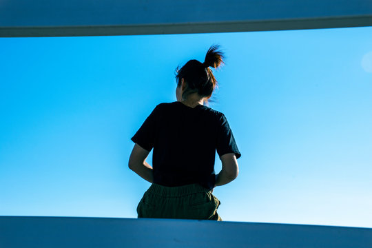 Girl Sitting Rear View, Against The Sky, Place For Text.