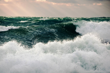 Storm green waves in the deep sea. Surging waves driven by the wind on sea water