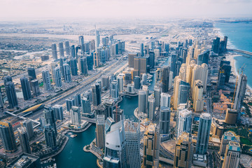Fototapeta na wymiar Aerial view of High rise buildings and futuristic architecture of Dubai Marina with man made lake flowing through