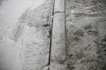 Road pits in the city in the spring after the snow melts. Problem of roads and asphalt in the city.