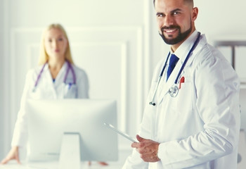 Happy medical team of doctors, man and woman, isolated over white background in a hospital room