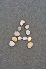 alphabet by stone on the beach