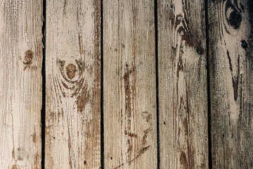 Texture of gray shabby wooden fence from old vertical boards with peeling paint