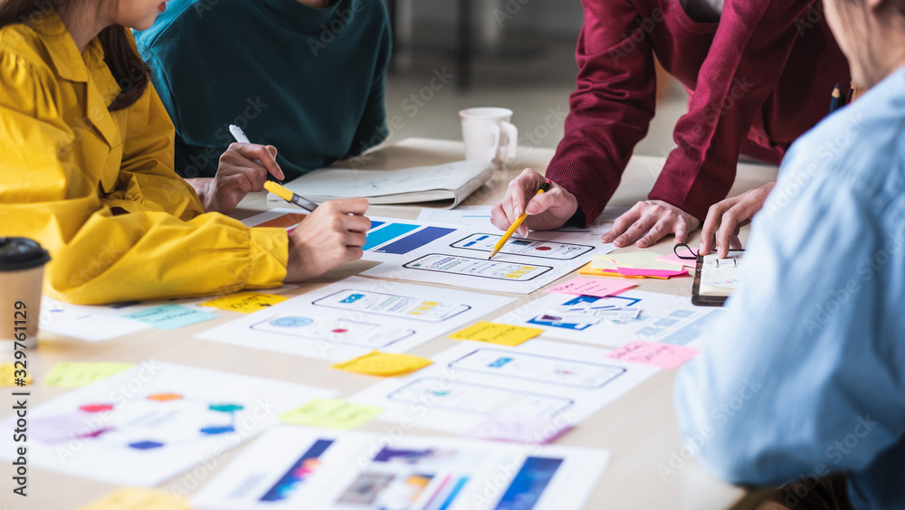 Poster Close up ux developer and ui designer brainstorming about mobile app interface wireframe design on table with customer breif and color code at modern office.Creative digital development agency.