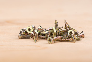 Metal screws on a wooden background. Copy space.