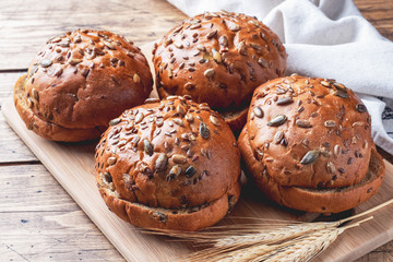 Bread products with cereals and seeds on a wooden background. Lean healthy buns, carbohydrate pastries.