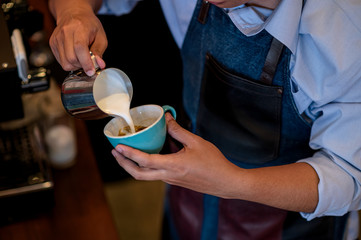 Fototapeta na wymiar The male barista making latte coffee