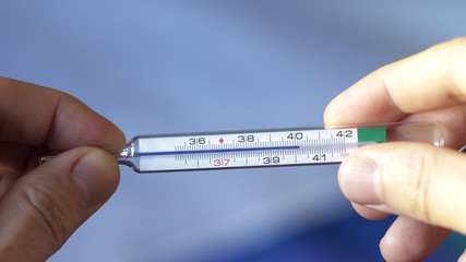 Checking temperature above 40 degrees celsius on gallium thermometer - obrazy, fototapety, plakaty