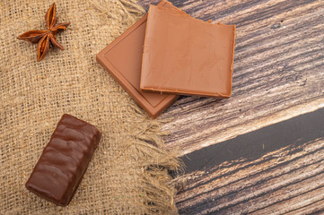 A glass of tea in a vintage Cup holder , star anise and pieces of brown sugar on a background of coarse fabric. Close up.