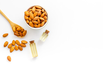 Skin care cosmetics. Almond oil in small bottles on white background top-down copy space