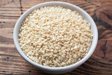 Organic natural sesame seeds on wooden spoon