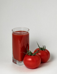 Juicy, ripe tomatoes and tomato juice in a glass.