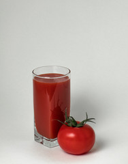 Juicy, red tomato and tomato juice in a glass.