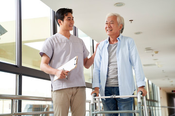 asian old man talking to physical therapist in rehab center