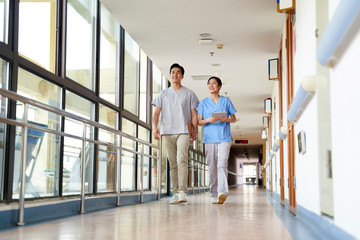 two medical worker colleagues walking chatting in nursing home hallway