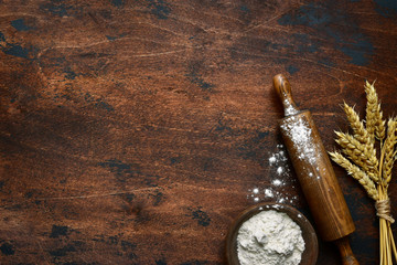 Baking background with flour, wheat ears and rolling pin. Top view with copy space.
