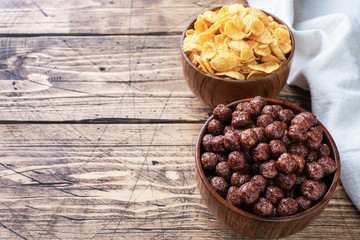 Chocolate flakes from natural cereals balls and corn flakes dry for Breakfast with milk. Wooden table. Copy space