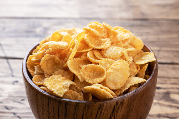 Dry flakes of corn and natural cereals for Breakfast with milk. Wooden background. Copy space