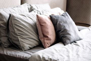 stack of folded decorative pillows on the bed
