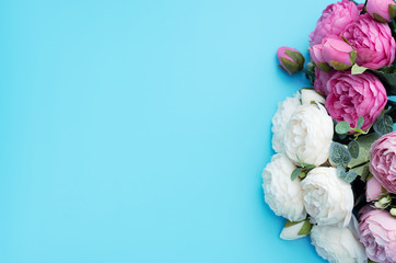 Pink and white flowers on blue background. Mother’s Day, Spring concept. Greeting, invitation card. Flat lay, top view style with copy space for your text.