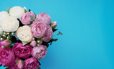 Pink and white flowers on blue background. Mother’s Day, Spring concept. Greeting, invitation card. Flat lay, top view style with copy space for your text.