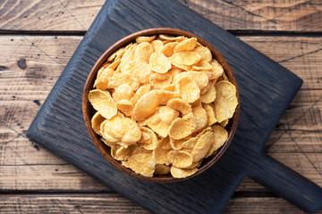 Dry flakes of corn and natural cereals for Breakfast with milk. Wooden background.
